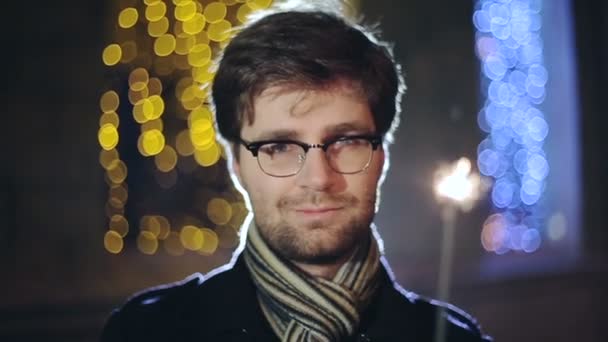 SLOW MOTION: Portrait of man with a sparkler in hand bokeh background — Stock Video