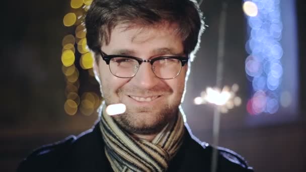 Man with a sparkler in hand bokeh background. — Stock Video