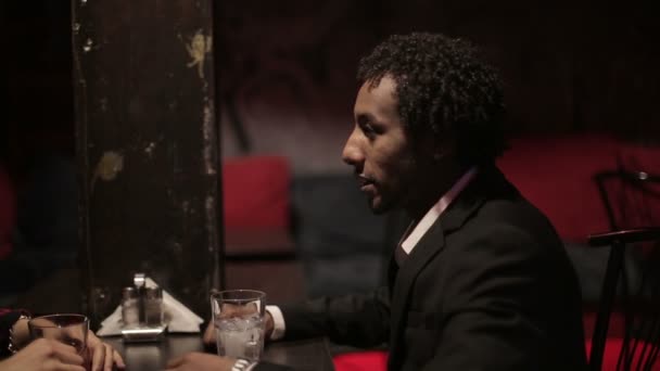 白人女性と黒人男性は、レストランでの対話を行います。異なる人種の友人. — ストック動画