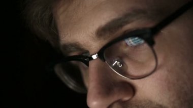 Geceleri çalışan genç bir adam gözlüklü portresi. Yakın çekim