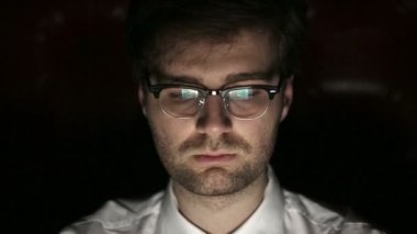 Geceleri çalışan genç bir adam gözlüklü portresi. Yakın çekim