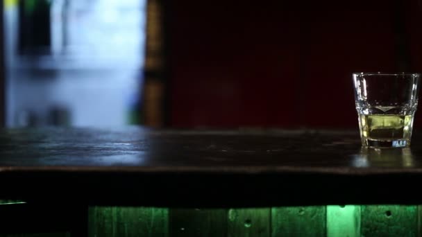 木製テーブルの上の氷とウイスキー。スライダーで撮影の Hd — ストック動画
