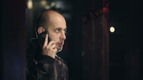 El hombre en el bar hablando por teléfono y bebiendo whisky con hielo — Vídeos de Stock