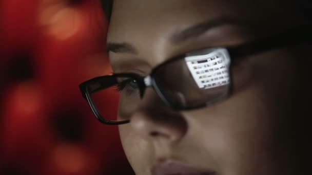 Retrato de una joven con gafas que trabaja de noche. De cerca. — Vídeos de Stock