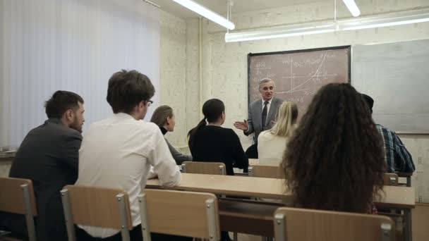 LOW MOTION: Grupo de alunos em uma sala de aula, ouvindo como seu professor realiza uma palestra . — Vídeo de Stock