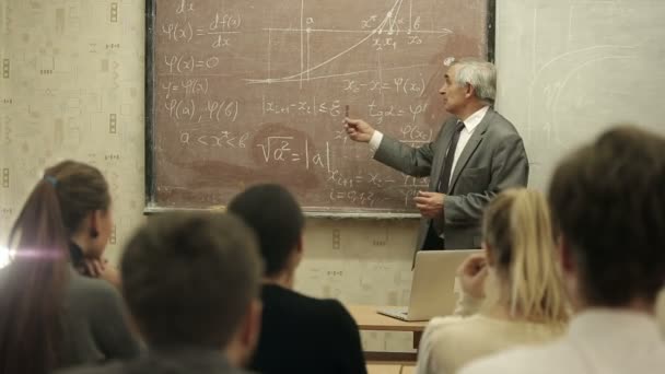 Groupe d'étudiants dans une salle de classe, à l'écoute de leur professeur tient une conférence . — Video