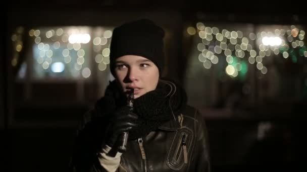 Tonåring flicka på kvällen på gatan röka elektronisk cigarett. — Stockvideo