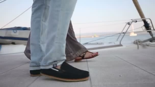 Man with a woman are on the pier to the boat. Feet close up slow motion — Stock Video