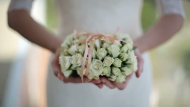 Bruid houdt een boeket van bloemen en trouwringen — Stockvideo