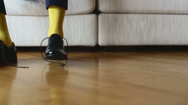 L'homme en chaussettes jaunes porte des chaussures pour attacher des lacets . — Video