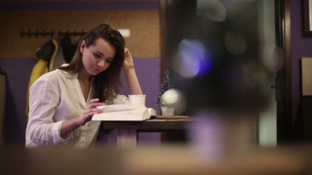 Μια φοιτήτρια σε μια καφετέρια που διαβάζει ένα βιβλίο. Αργή κίνηση — Αρχείο Βίντεο