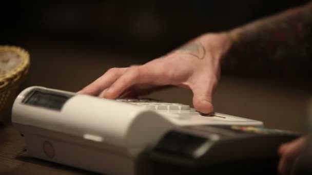 Πωλητή άνθρωπος με τατουάζ για τα χέρια και την ταμειακή μηχανή — Αρχείο Βίντεο