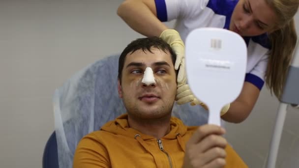 Oroszország, Szentpétervár - 2013: Egy ember néz egy arc plasztikai műtétek után — Stock videók