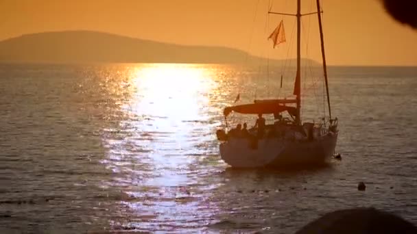 Yate en el mar al atardecer sobre un fondo de montañas — Vídeo de stock