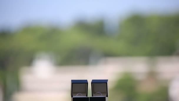 Anillos de boda en las cajas en el balcón sobre un fondo de una ciudad exótica — Vídeos de Stock