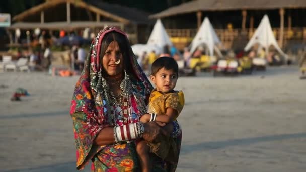 Indien, Goa - 2012: Gammal indisk kvinna i traditionell klädsel innehar ett barn — Stockvideo