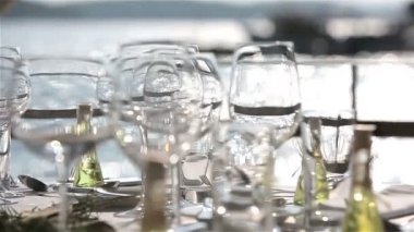 Tepsi şampanya bardakları eller garsona arka planını günbatımı denizde. Yakın çekim