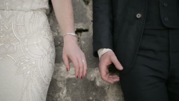 Hombre y mujer adultos tomados de la mano en el fondo de la pared de piedra — Vídeo de stock