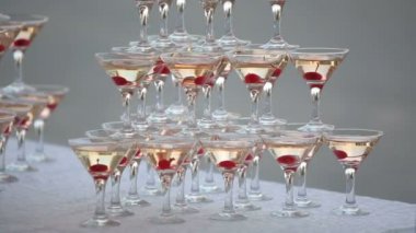 Pyramid from glasses with champagne with cherry in glasses