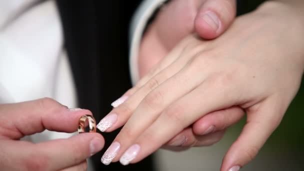 A man puts his woman a wedding ring on the finger. Close up macro — Wideo stockowe