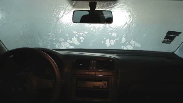 Automatic car wash. From the inside. Roller soaping and scrubbing the windshield — Stock Video