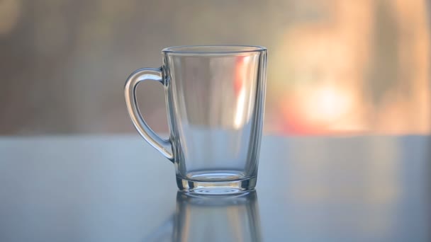 Agua caliente sobre el té en taza de vidrio transparente — Vídeos de Stock