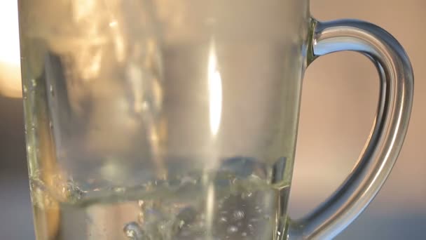 Eau chaude sur le thé dans une tasse en verre transparent — Video