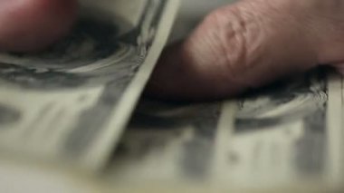Yüz dolar faturaları bir masada sayma bir işadamı eller yukarı kapatın. Ağır çekim