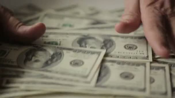 Hände eines Geschäftsmannes, die an einem Tisch Hundert-Dollar-Scheine zählen — Stockvideo
