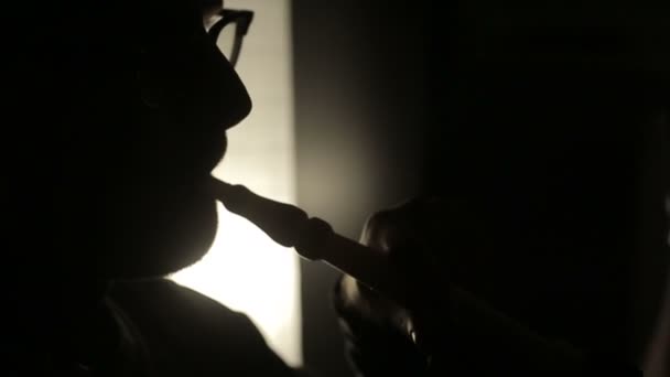 SLOW MOTION: Shadow of a man smoking a hookah. — Stock Video