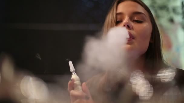 Медленное движение: Девушка отдыхает вечером в кафе курит кальян в ожидании друзей — стоковое видео