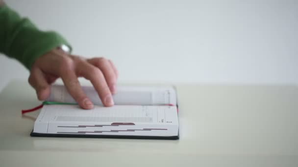 Närbild av hand pennan skriver i en anteckningsbok — Stockvideo