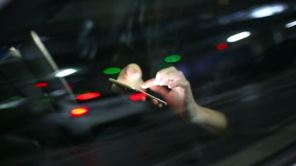 Mujer atractiva joven utilizando el teléfono móvil en el coche en el aparcamiento subterráneo — Vídeo de stock
