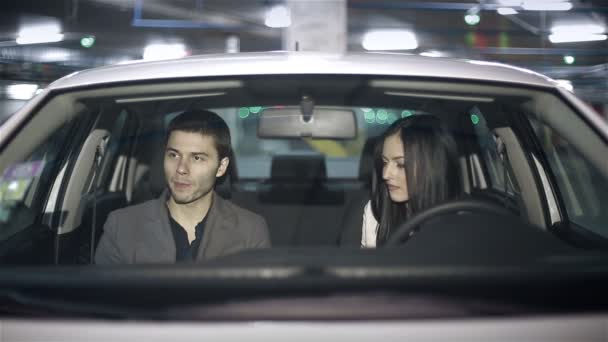 Emociones de una joven pareja en el coche en el aparcamiento subterráneo — Vídeo de stock