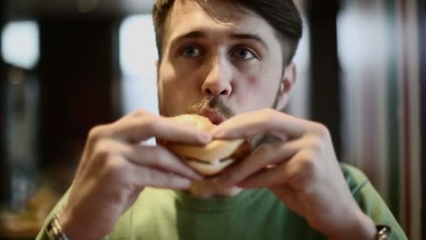 Homme mangeant hamburger — Video