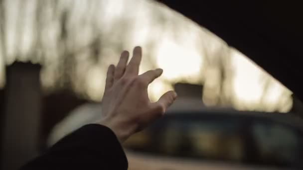 Een man golven zijn hand in de wind — Stockvideo