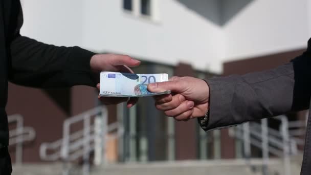 Männer reichen einander Geld-Euro-Scheine und schütteln Hände. — Stockvideo