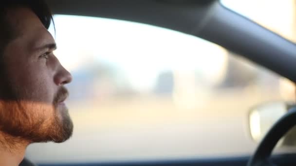 Een man rijdt een auto. Close-up van profiel schot — Stockvideo