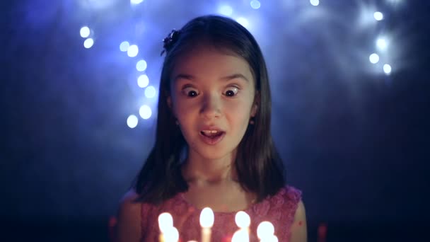 День народження маленької дівчинки вона вибухає свічки на торт. фон Боке — стокове відео