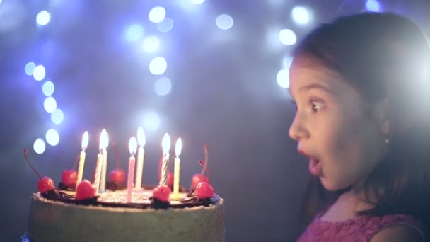 Birthday of the little girl she blows out candles on cake. Bokeh background — Stock Video