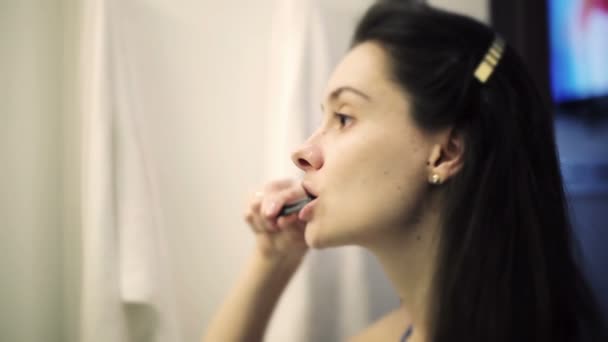Jovem mulher escovando dentes no banheiro do hotel para checkout — Vídeo de Stock