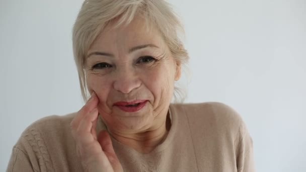 Senior portré, boldog idős asszony és mosolyogva néz a kamera. Lassú mozgás — Stock videók