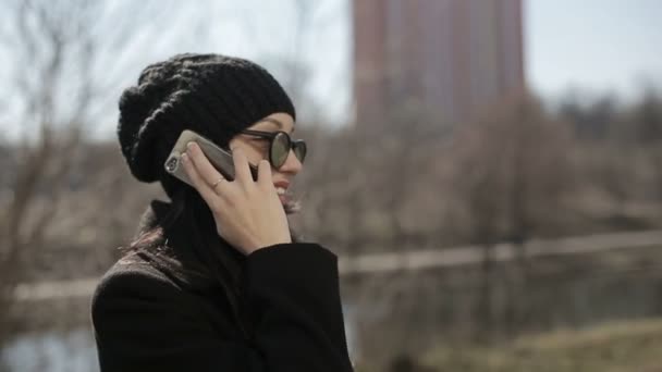 Young girl in sunglasses speaks by phone. Slow motion — Stock Video