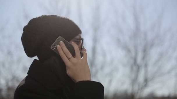 Chica joven en gafas de sol habla por teléfono. De cerca. — Vídeos de Stock