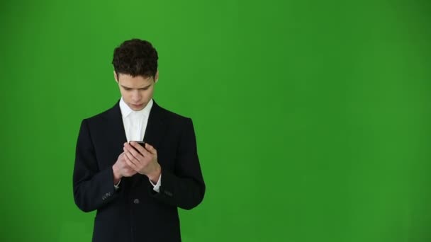 Mladý podnikatel pomocí smartphone na chroma klíč pozadí — Stock video