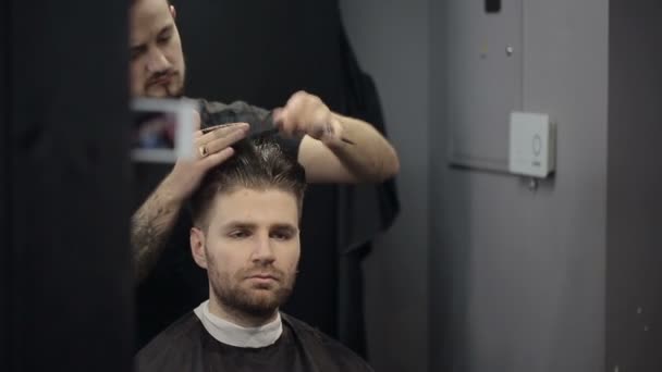 Barbeiro corta o cabelo na barbearia — Vídeo de Stock