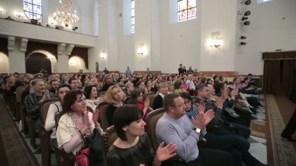 Bělorusko, Minsk - 8 dubna 2015: dětský sbor koncert. Mnoho mužů a žen sedět na koncertě a tleskat — Stock video