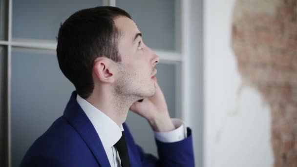 Hombre de negocios guapo hablando por teléfono y mirando hacia arriba — Vídeo de stock