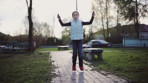 Meisje springtouw bij zonsondergang — Stockvideo