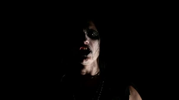 Sänger einer Black-Metal-Band. Gesicht aus nächster Nähe vor dunklem Hintergrund — Stockvideo